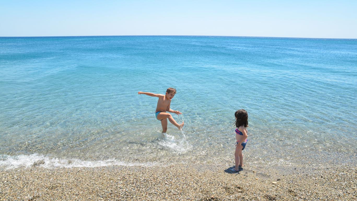 Kinderen spelen in de on-Europees mooie zee van Calabrië