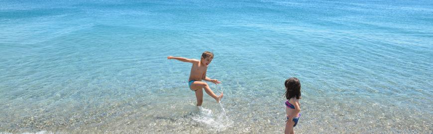 Kinderen spelen in de on-Europees mooie zee van Calabrië